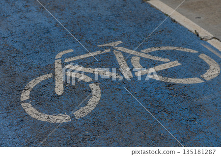 Bicycle lane marking on a vibrant blue pavement indicating safe space for cyclists in an urban setting Bicycle lane marking on a vibrant blue pavement indicating safe space for cyclists in an urban setting 135181287