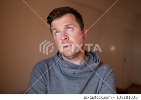 Skeptical male person reacting to a lie or stupid question, looking bored and fed up. 135181330