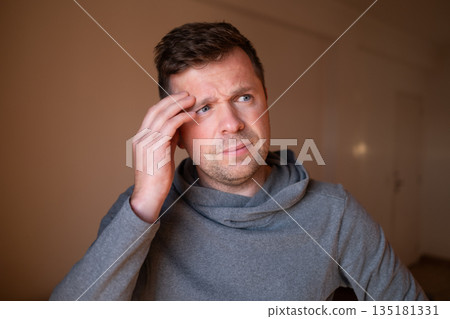 Stressed male having a terrible headache or migraine pain, touching temple. 135181331