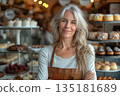 Smiling Mature Woman Standing In Pastry Shop 135181689