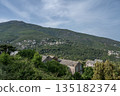 panoramic view village mountainous landscape towards the Gulf of Porto in sunlight with blue skies and spectacular cloud 135182374