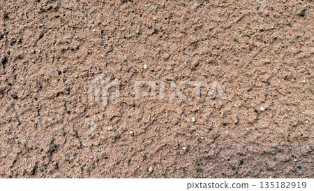 Close-up of a rough textured wall with pinkish sand and gravel plaster. Close-up of a rough textured wall with pinkish sand and gravel plaster. 135182919