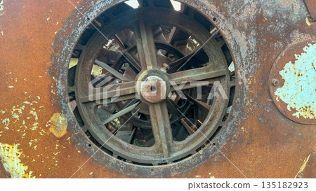 Front view of a weathered industrial rusted metal machine housing with rotor blades. 135182923