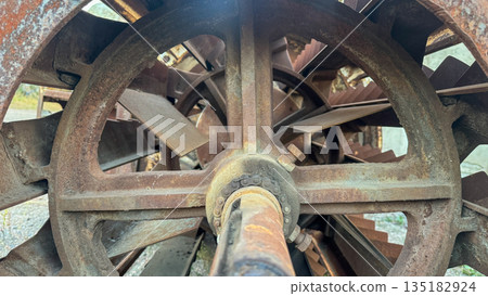 Heavy industrial rusted metal machine with paddles and chain drive. 135182924