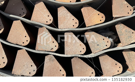 Repetitive industrial pattern of rusty metal teeth and machinery parts 135182930
