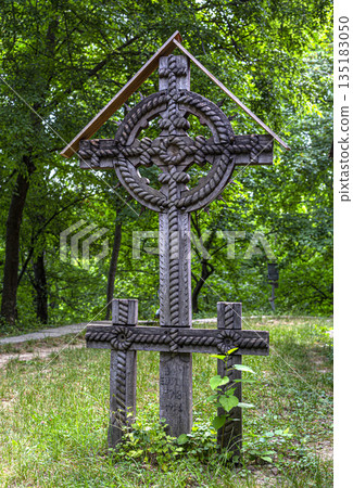 Carved wooden celtic cross monument in romanian forest cemetery Carved wooden celtic cross monument in romanian forest cemetery 135183050