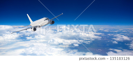 Commercial jet flying above fluffy white clouds Commercial jet flying above fluffy white clouds 135183126