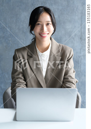 在辦公室使用筆記本電腦的女人 在辦公室使用筆記本電腦的女人 135183165