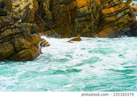 Waves of the East Sea crash against the breakwater and rocky shore, South Korea 135183379