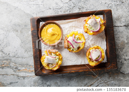 Baked potato cups stuffed with egg salad and salted herring close-up on a wooden board. Horizontal top view Baked potato cups stuffed with egg salad and salted herring close-up on a wooden board. Horizontal top view 135183678