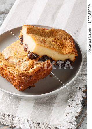 French far breton a pudding with prunes and rum closeup on the plate. Vertical 135183699