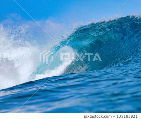 Blue wave breaking on a beach in sea 135183921