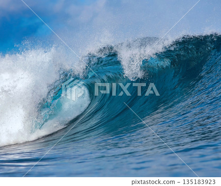 Blue wave breaking on a beach in sea Blue wave breaking on a beach in sea 135183923