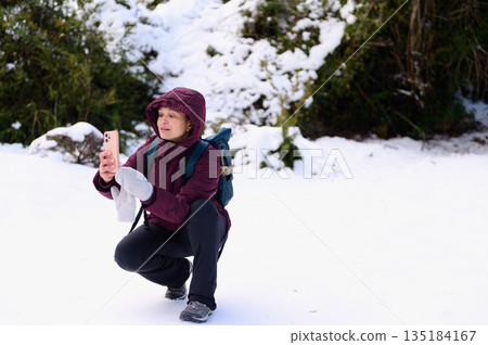Woman Taking Selfie in Snowy Forest During Winter Hike With Backpack Woman Taking Selfie in Snowy Forest During Winter Hike With Backpack 135184167