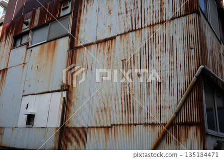 A dilapidated and rusty factory, an abandoned local factory 135184471