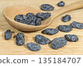 Dark raisins and wooden spoon on the wooden surface 135184707