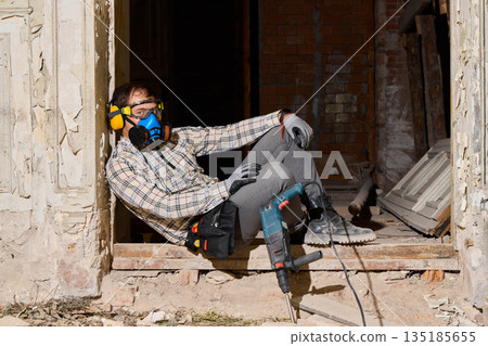 Urban renovation contractor cutting concrete with angle grinder 135185655