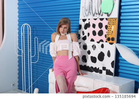 Person arranging store display with vibrant decor and stylish outfit Person arranging store display with vibrant decor and stylish outfit 135185694