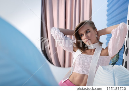 Chic woman seated comfortably on cozy sofa in peaceful surroundings Chic woman seated comfortably on cozy sofa in peaceful surroundings 135185720
