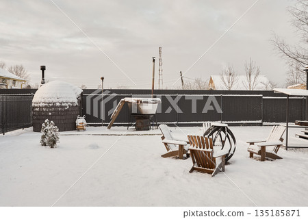 Serene winter evening scene around crackling outdoor fire 135185871