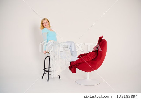 Blonde white product reviewer testing stool and chair setup Blonde white product reviewer testing stool and chair setup 135185894