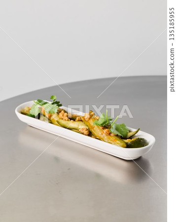 Herb and walnut garnish complements asparagus presentation 135185955