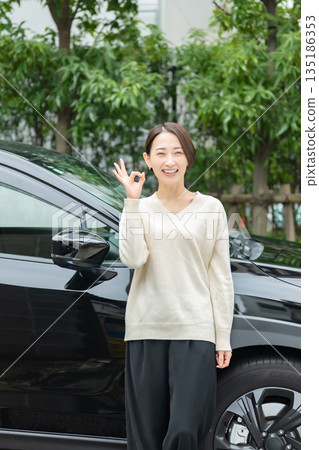 站立在汽車前面的婦女 站立在汽車前面的婦女 135186353