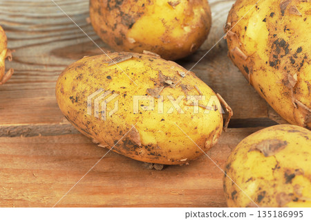 whole raw potatoes in their skins on a wooden whole raw potatoes in their skins on a wooden 135186995