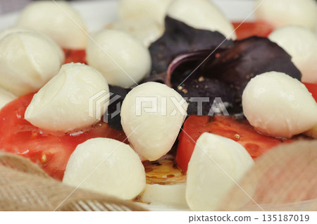 Caprese salad - tomatoes, basil and mozzarella cheese Caprese salad - tomatoes, basil and mozzarella cheese 135187019