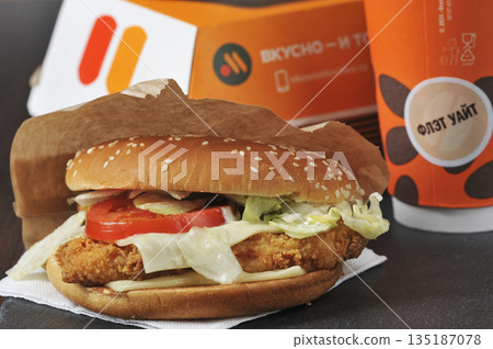 chicken patty burger with cheddar cheese and flat white coffee from the Tasty and Dot restaurant in Moscow 135187078