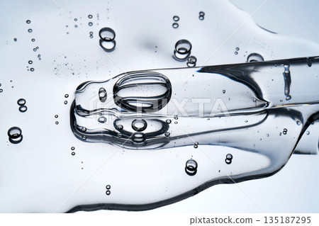 Clear liquid serum with pipette showing bubbles texture Clear liquid serum with pipette showing bubbles texture 135187295