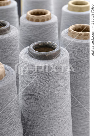 Group of large spools of thread of gray color 135187560