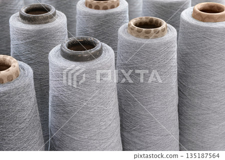 Group of large spools of thread of gray color Group of large spools of thread of gray color 135187564