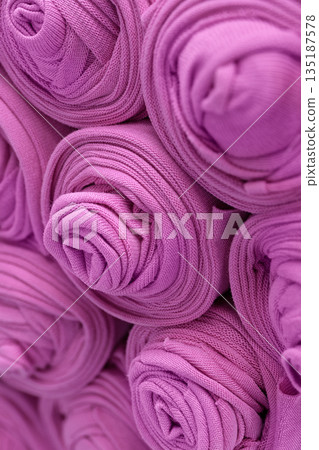 Knitted pink fabric rolled into rolls 135187578