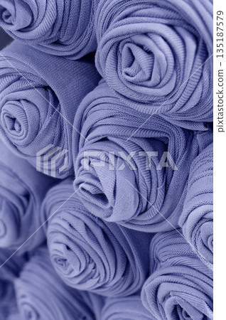 Knitted blue fabric rolled into rolls 135187579