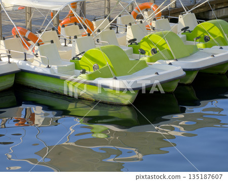 Green catamarans at the pier in the amusement park Green catamarans at the pier in the amusement park 135187607