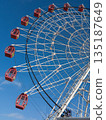 Ferris wheel cabins against a blue sky. 135187649