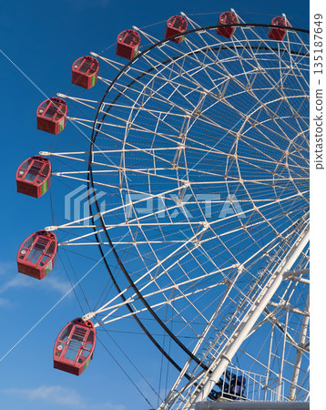 Ferris wheel cabins against a blue sky. Ferris wheel cabins against a blue sky. 135187649