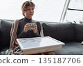 young woman warms up with hot tea in winter weather at home 135187706