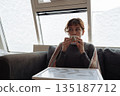young woman warms up with hot tea in winter weather at home 135187712