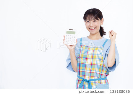 A housewife holding a calculator and giving a fist pump A housewife holding a calculator and giving a fist pump 135188086