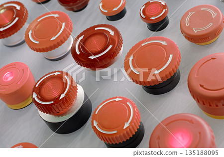 Multiple red emergency stop buttons on a grey metal panel 135188095