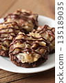 German Chocolate Cookies with Coconut, Pecan Topping, and Chocolate Drizzle 135189035