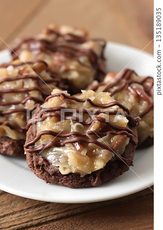 German Chocolate Cookies with Coconut, Pecan Topping, and Chocolate Drizzle 135189035