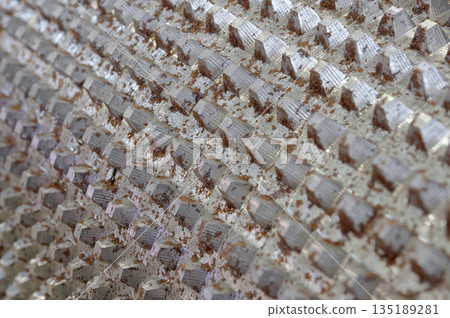 Surface of steel cylinder covered with spikes, industrial equipment part 135189281