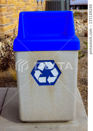 Blue recycling bin is placed in public space with concrete natural surroundings items can be discarded here. 135189288
