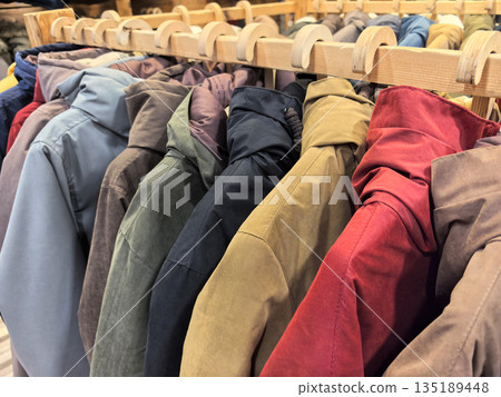 Stylish coats hanging neatly in a boutique during autumn season Stylish coats hanging neatly in a boutique during autumn season 135189448