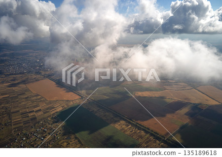 Aerial view at high altitude of earth covered with puffy cumulus clouds forming before rainstorm 135189618