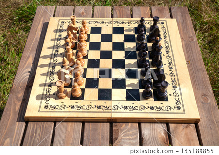 Chessboard with Chess Pieces on Table Chessboard with Chess Pieces on Table 135189855