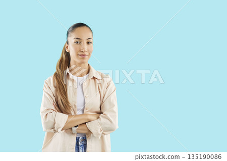 Young woman standing with crossed arms in casual clothes on blue studio background. 135190086